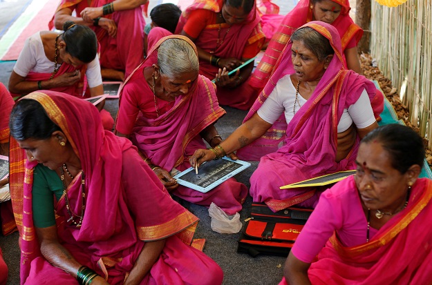Kantabai More (R), 65, helps her classmate Anusuya Kokedar (3rd L), 65, as she writes on a slate at Aajibaichi Shaala (Grandmothers' School) in Fangane village, India. PHOTO: REUTERS