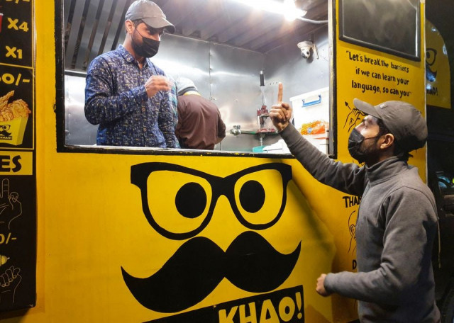 people communicate using sign language outside pakistan s first mobile restaurant staffed entirely by deaf workers in islamabad pakistan february 23 2022 photo reuters people communicate using sign language outside pakistan s first mobile restaurant staffed entirely by deaf workers in islamabad pakistan february 23 2022 photo reuters