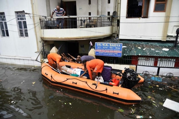 Rainwater swamped hospital wards and residential areas where disaster management officials delivered vital supplies. PHOTO: AFP