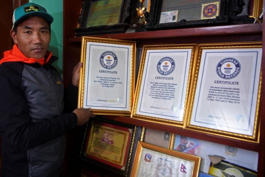 Nepal's mountaineer Kami Rita Sherpa, who has climbed Everest a record 24 times, poses with his certificates.PHOTO: AFP