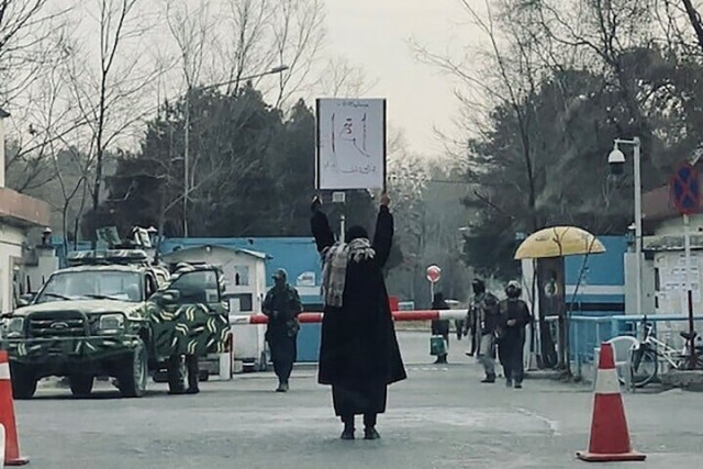 this picture shows student marwa protesting alone against the ban on women s higher education outside the kabul university as members of taliban stand guard in kabul on december 25 2022 photo afp this picture shows student marwa protesting alone against the ban on women s higher education outside the kabul university as members of taliban stand guard in kabul on december 25 2022 photo afp