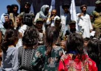 afghan girls look at taliban supporters on the second anniversary of the fall of kabul on a street near the us embassy in kabul afghanistan august 15 2023 reuters