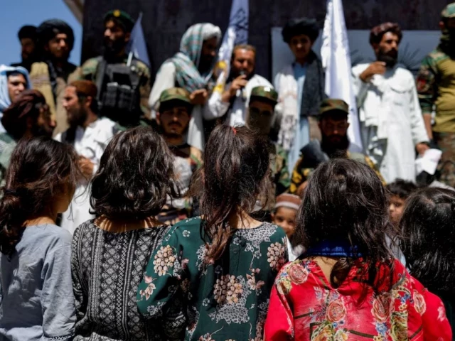 afghan girls look at taliban supporters on the second anniversary of the fall of kabul on a street near the us embassy in kabul afghanistan august 15 2023 reuters afghan girls look at taliban supporters on the second anniversary of the fall of kabul on a street near the us embassy in kabul afghanistan august 15 2023 reuters