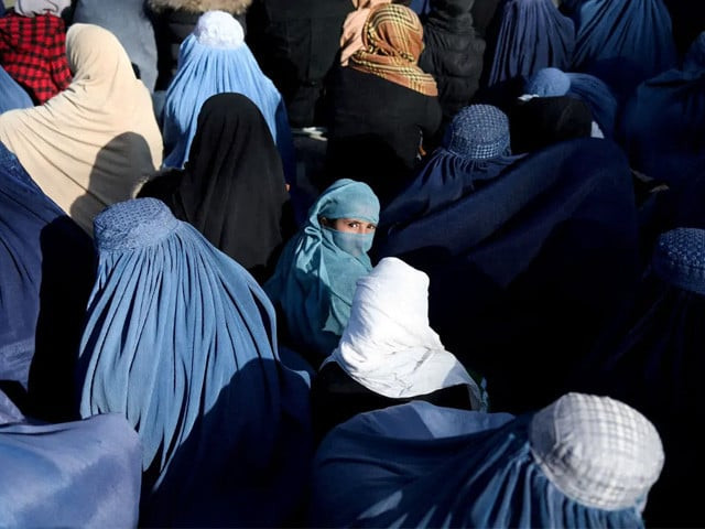 a girl sits in front of a bakery in the crowd with afghan women waiting to receive bread in kabul afghanistan january 31 2022 photo reuters
