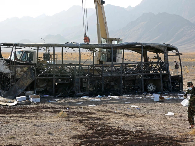 security personnel stand guard at the site of a bus crash in guzara district of herat province on august 20 2025 the death toll from a collision between a bus carrying afghan migrants returning from iran and two other vehicles in western afghanistan has risen to 76 a provincial official said on august 20 photo afp