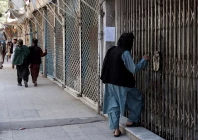 afghan men walk past shops closed in solidarity with victims of an attack by unidentified armed men on the outskirts of the sayed mohammad agha shia shrine photo afp