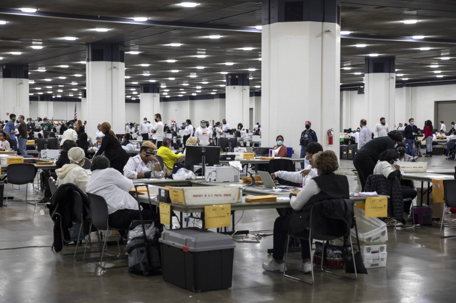 workers with the detroit department of elections process absentee ballots at the central counting board in the tcf center on november 4 2020 in detroit michigan   afp