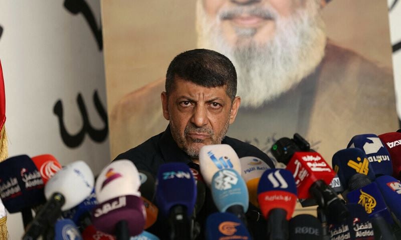 hezbollah spokesman mohammad afif speaks in front of a portrait of late hezbollah chief hassan nasrallah during a press conference in south beirut on november 11 2024 amid the ongoing war between israel and hezbollah photo afp