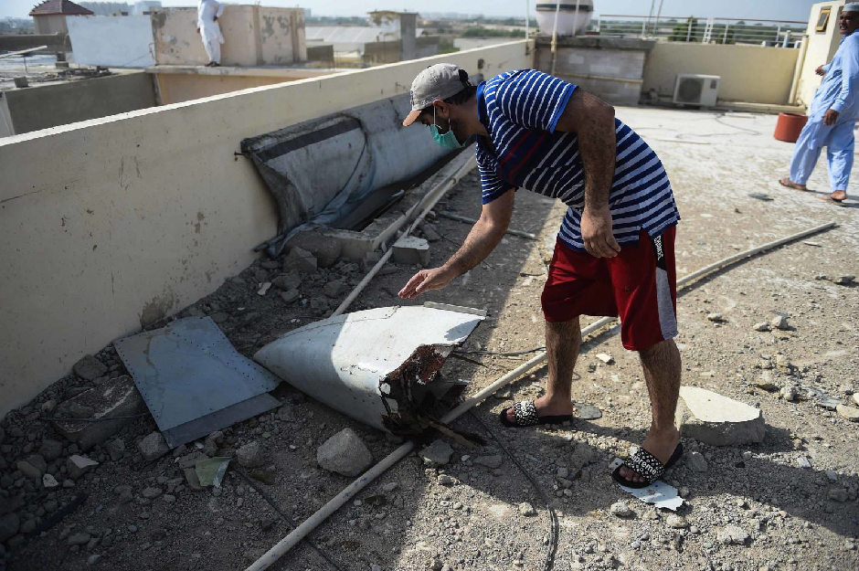 A man looks at a part of the plane's debris. PHOTO: AFP