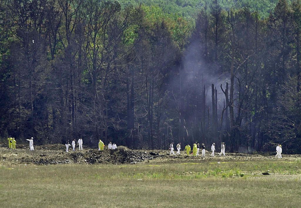 Investigative personnel search the crash site of United Airlines Flight 93 looking for debris and evidence on 12 September 2001 in Shanksville, Pennsylvania. The hijacked plane crashed, killing all people on board. [Photo: AFP]