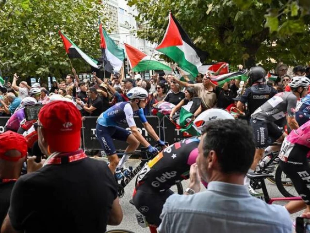 team israel premier tech s italian rider marco frigo c rides next to pro palestinian demonstrators at the start of the 12th stage of the vuelta a espana a 144 9 km race between laredo and corrales de buelna on sept 4 2025 photo afp