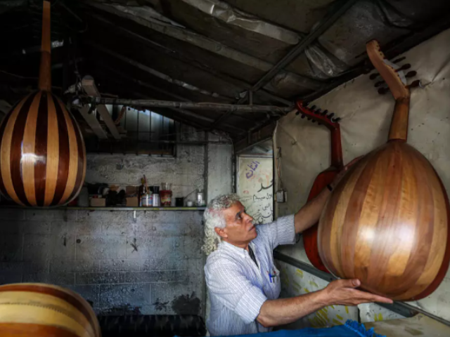 Photo: Palestinian craftsman Suhail Abu Shawish repairs damaged Ouds/ AFP