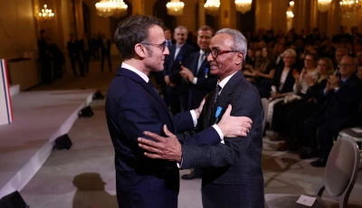 french president emmanuel macron l wearing sunglasses awards the chevalier of the french order of merit to ali akbar who hawks newspapers around the streets of saint germain des pres in the french capital for 50 years at the elysee palace in paris on january 28 2026 photo afp