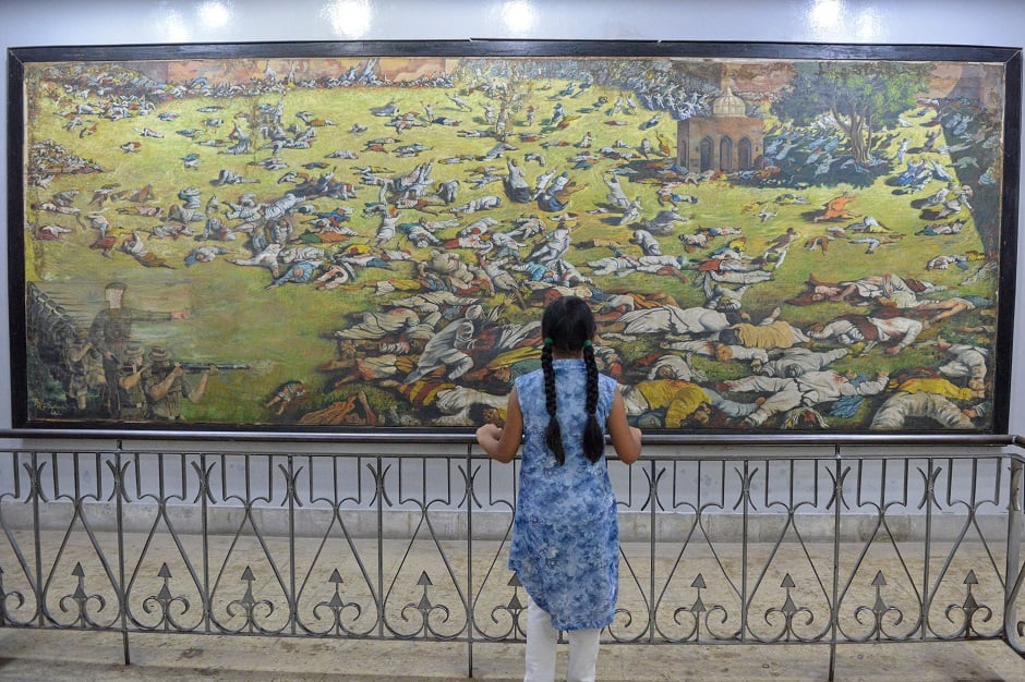 In this file photo taken on April 7, 2019, an Indian girl looks at a painting of those killed ahead of the 100th anniversary of the Jallianwala Bagh massacre in Amritsar. PHOTO: AFP