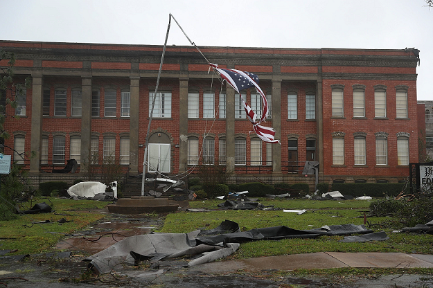 An American flag flies from a broken flag pole. PHOTO  AFP