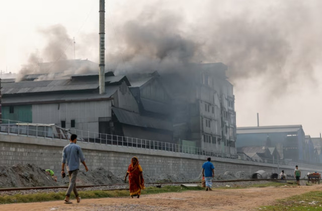 commuters pass an industrial area as smoke rises from re rolling factories at the shyampur area of dhaka bangladesh march 16 2024 photo reuters