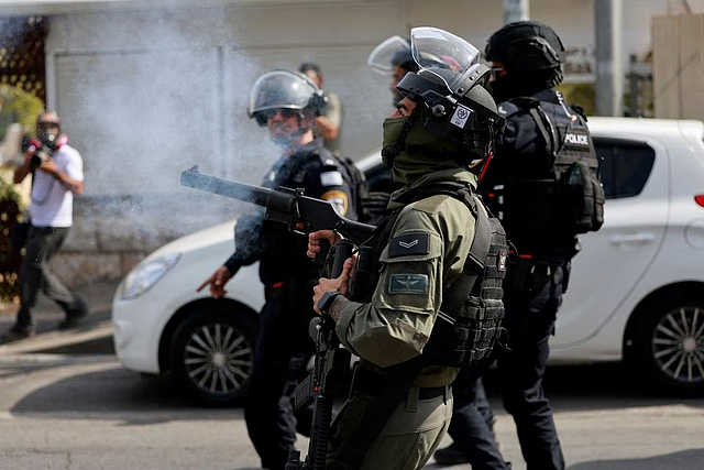 An Israeli border police officer fires a crowd control gas canister, as Muslim Palestinians try to hold Friday prayers by a road outside the Old City of Jerusalem, as the conflict between Israel and Hamas continues, in Jerusalem, October 27, 2023. PHOTO: REUTERS