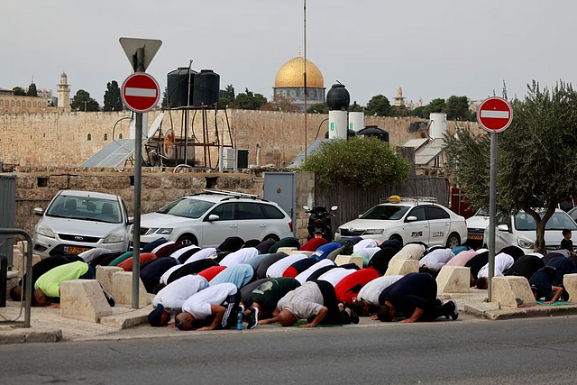 Muslim Palestinians hold Friday prayers by a road outside the Old City of Jerusalem, as the conflict between Israel and Hamas continues, in Jerusalem, October 27, 2023. PHOTO: REUTERS