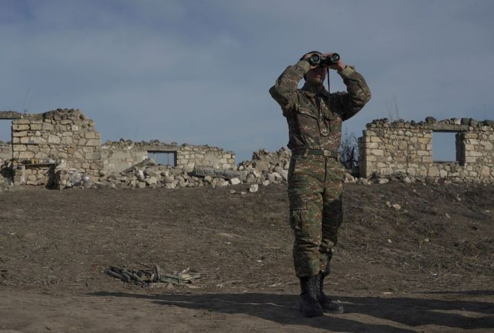 an ethnic armenian soldier looks through binoculars as he stands at fighting positions near the village of taghavard in the region of nagorno karabakh january 11 2021 picture taken january 11 2021 reuters artem mikryukov