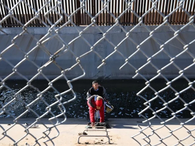 a family from columbia climbs up through a canal fence after crossing under a hole in the us mexico border wall in el paso texas photo afp