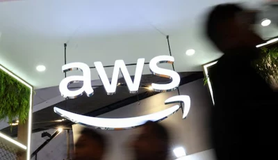 people walk past the logo of amazon web services aws at its exhibitor stall at the india mobile congress 2025 at yashobhoomi a convention and expo center in new delhi india october 8 2025 photo reuters