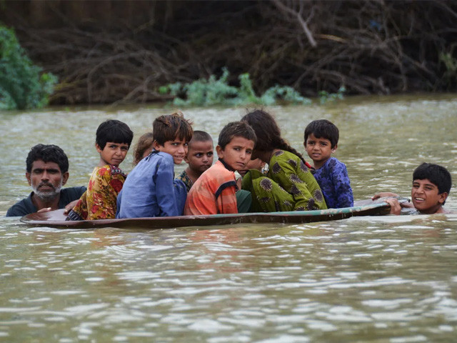 a satellite dish is used to move children through floodwaters in jaffarabad balochistan photo afp