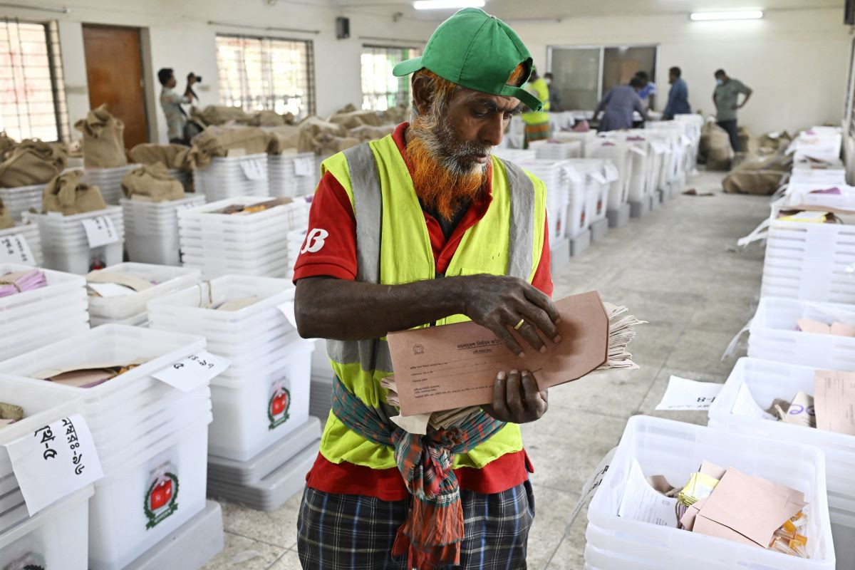 10 فروری ، 2026 ، بنگلہ دیش کے ڈھاکہ میں ، قومی انتخابات سے قبل بیلٹ بکس کے ساتھ بھیجنے کے لئے ایک شخص لفافے تیار کرتا ہے۔