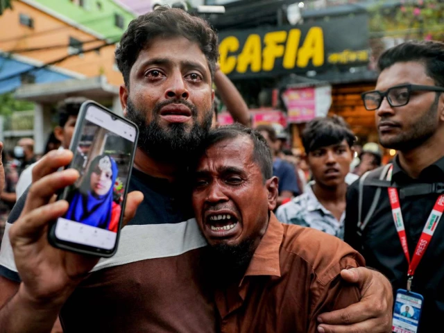a relative shows a picture of a fire accident victim who works as a garment factory worker outside the chemical and garments factory in dhaka on october 14 2025 at least 16 people were killed after a fire blazed through a chemical and garments factory in dhaka photo afp a relative shows a picture of a fire accident victim who works as a garment factory worker outside the chemical and garments factory in dhaka on october 14 2025 at least 16 people were killed after a fire blazed through a chemical and garments factory in dhaka photo afp