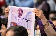 an activist holds a poster of sharif osman hadi senior leader of the student protest group inqilab mancha who was shot outside a mosque during a demonstration to condemn the attack in dhaka on december 15 2025 photo afp