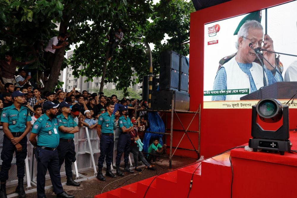 People watch Muhammad Yunus, leader of Bangladeshi interim government, as he appears on a screen while reading the July Declaration, during celebrations marking the one-year anniversary of student-led protests that led to the ousting of Bangladeshi then-Prime-Minister Sheikh Hasina, at Manik Mia Avenue, outside the parliament building, in Dhaka, Bangladesh, August 5, 2025.PHOTO: REUTERS