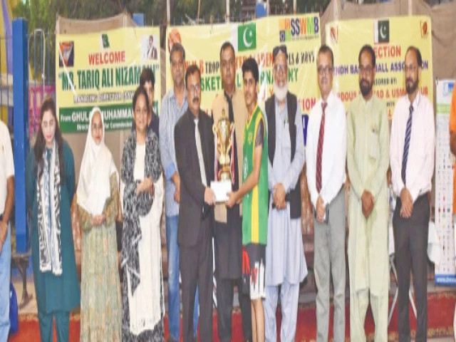 winning captain of abdul nasir academy receives his sswmb inter academy basketball trophy from chief guest tariq nizamani photo kba