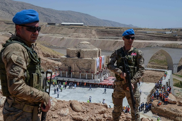 Tukish soldiers stand guard as the Artuklu Hamam, a centuries-old bath house weighing 1,600 tonnes, is loaded onto a wheeled platform an moved down a specially constructed road, on August 6, 2018. PHOTO: AFP