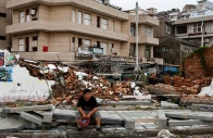 a person sits beside a collapsed wall in the aftermath of typhoon bavi in the coastal village of dongsha taizhou zhejiang province china july 12 2026 photo reuters