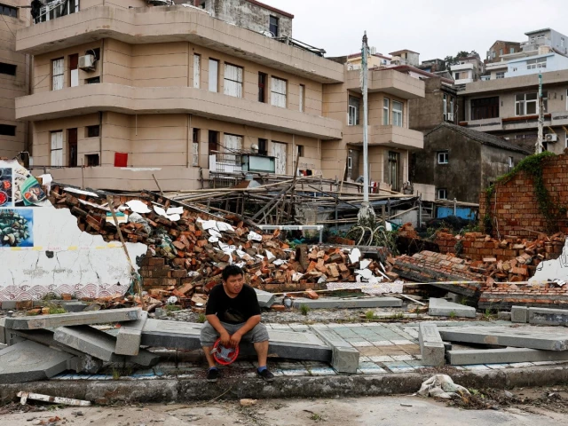 a person sits beside a collapsed wall in the aftermath of typhoon bavi in the coastal village of dongsha taizhou zhejiang province china july 12 2026 photo reuters a person sits beside a collapsed wall in the aftermath of typhoon bavi in the coastal village of dongsha taizhou zhejiang province china july 12 2026 photo reuters