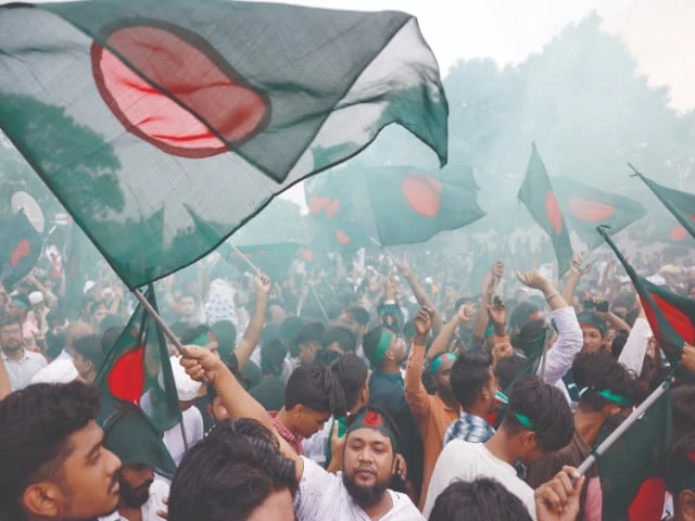 people wave flags during celebrations marking the first anniversary of student led protests against sheikh hasina s government in dhaka photo reuters