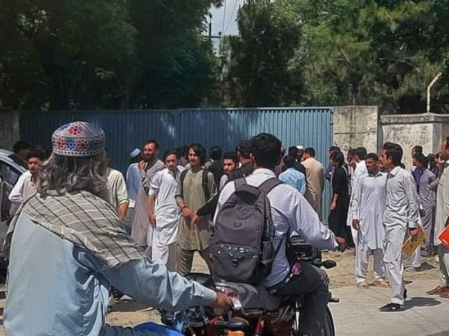 students stand outside school premises after shooting