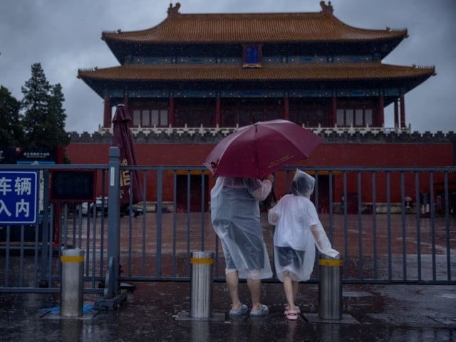people in raincoats stand at the closed gates of the forbidden city during heavy rain in beijing china july 30 2023 photo reuters