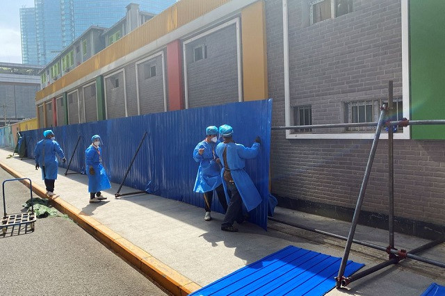 workers in protective clothing erect barricades outside a residential building under lockdown in chaoyang district amid the coronavirus disease covid 19 outbreak in beijing china may 4 2022 reuters tony munroe