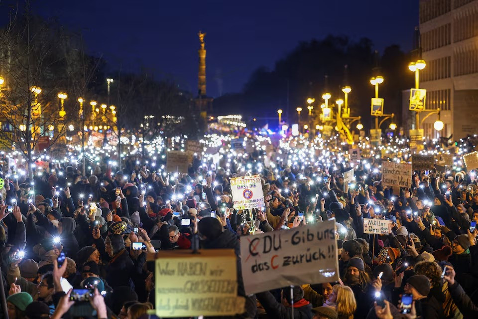 people light up their mobile phones during a protest against the migration plans of the cdu party leader and top candidate for chancellor friedrich merz and the far right alternative for germany party afd in berlin germany on february 2 2025 photo reuters