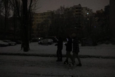 people walk through a darkened street during a blackout caused by a fire at a power distribution system in berlin germany january 3 2026 photo reuters