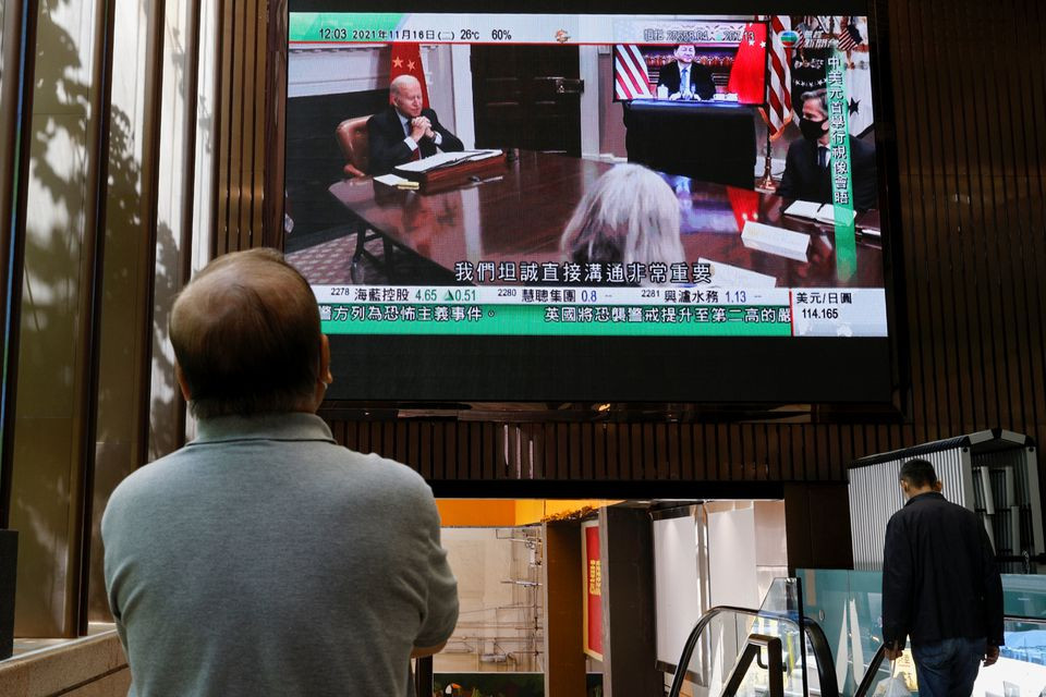 a tv screen shows news of a video meeting between u s president joe biden and chinese president xi jinping in hong kong china november 16 2021 photo reuters file