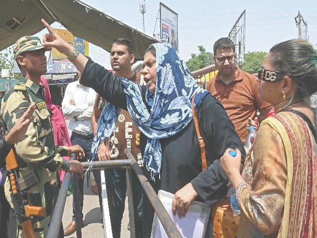 a woman an indian citizen who was married to a pakistani man speaks to bsf soldiers demanding to allow her through the wagah border post photo afp