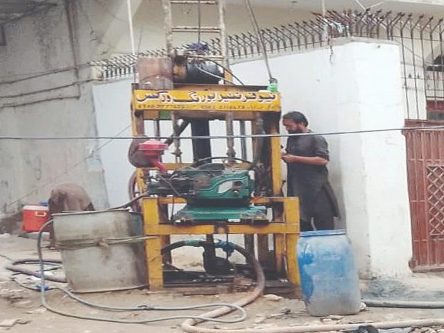 a worker operates a ground boring machine for drilling a tube well in a karachi neighbourhood photo express a worker operates a ground boring machine for drilling a tube well in a karachi neighbourhood photo express