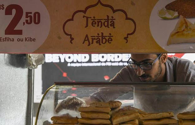 Egyptian immigrant Mohamed Ali Abdelmoatty Kenawy, who was attacked three weeks ago in what appeared to be a hate crime, works at his food stand in Rio's Copacabana neighborhood. PHOTO: AFP