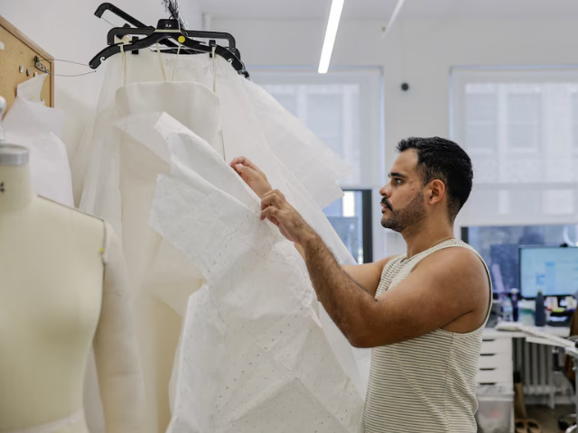 Designer Jose Alarcon works on a dress at the Jenny Yoo bridal boutique in New York City, U.S., August 6, 2026. PHOTO: Reuters