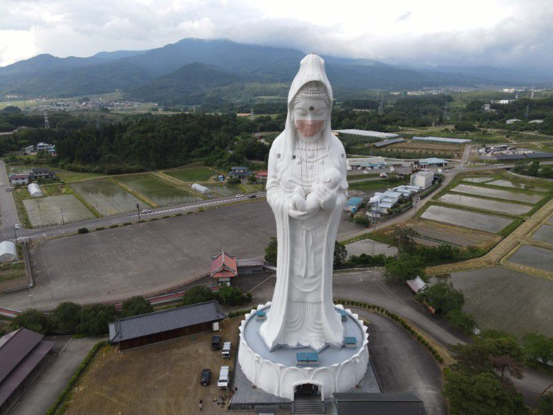a drone picture shows a mask placed on a 57 metre high statue of buddhist goddess kannon to pray for the end of the coronavirus disease covid 19 pandemic at houkokuji aizu betsuin temple in aizuwakamatsu fukushima prefecture japan photo reuters