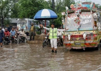 police officer controls traffic while standing amid rain waters in karachi photo reuters file police officer controls traffic while standing amid rain waters in karachi photo reuters file