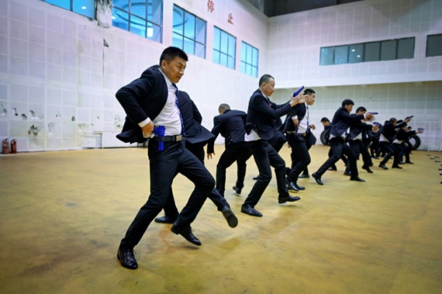 students in matching black business suits toil from dawn until midnight at the bodyguard school in the eastern chinese city of tianjin afp students in matching black business suits toil from dawn until midnight at the bodyguard school in the eastern chinese city of tianjin afp