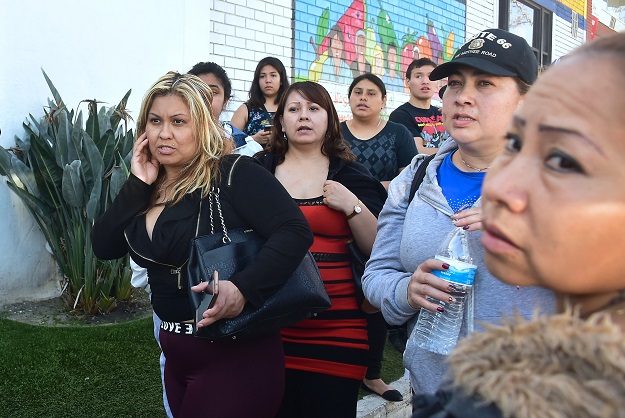 Parents wait and listen for any news from outside a roadblock to Salvadore Castro Middle School in Los Angeles, California. PHOTO:AFP