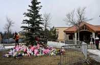 workers install a fence around a makeshift memorial for the victims two days after a deadly mass shooting took place at a school in the town of tumbler ridge british columbia canada february 12 2026 photo reuters